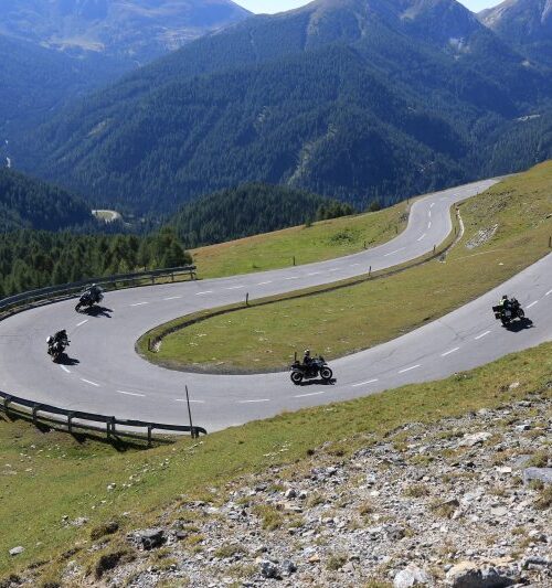 Motorrijders in haarspeldbochten tijdens dag 2 van de motorreis Oostenrijk Italië Slovenië; panoramische Alpenroute met strak asfalt.